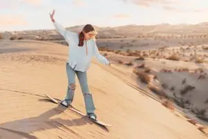 Tourist,Sandboarding,Down,A,Sunlit,Dune,In,The,Desert,,Embracing - Flair Travel & Holidays