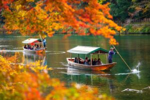 Tourists exploring Kyoto, Japan, during autumn, surrounded by colorful fall foliage and cultural attractions.